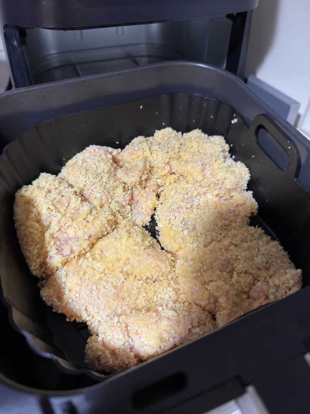 Pollo empanizado en la canasta de la freidora de aire