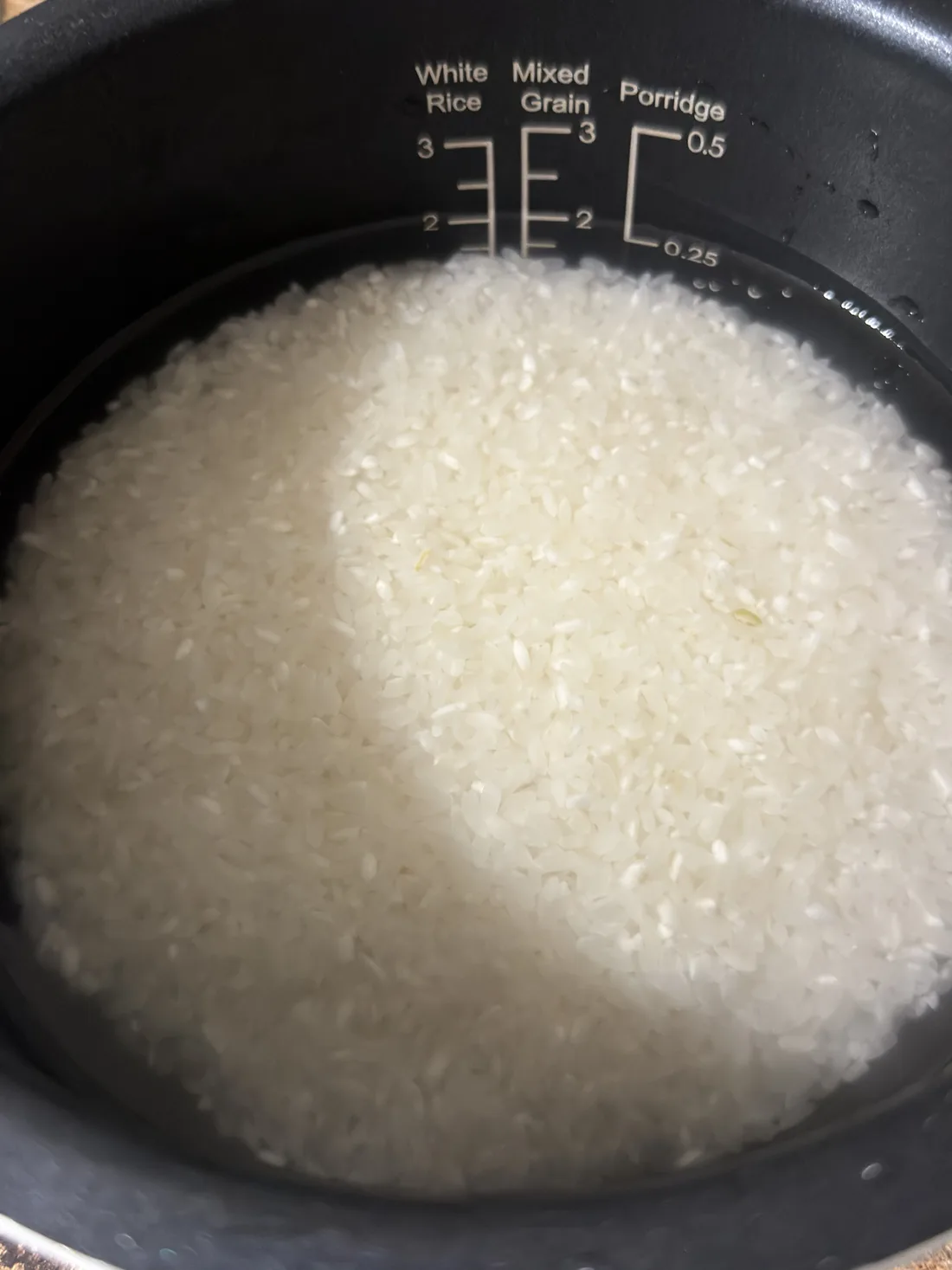 Rinsed Japanese short-grain rice and water in a rice cooker pot